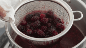 After simmering, pour the mixture through a fine-mesh sieve or cheesecloth into a clean bowl or jar. Gently press the berries to extract as much liquid as possible. (Don’t press too hard, or the syrup may turn cloudy.)