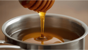 Close-up of honey being poured into a small saucepan.
