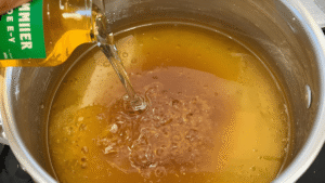 Vinegar being poured into the warm honey mixture.