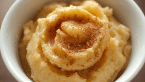 A warm mashed banana sprinkled with cinnamon, soft golden evening light.