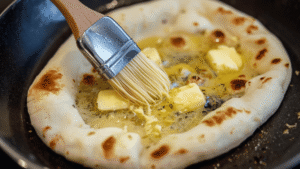 As soon as the naan comes off the heat, I brush it with melted butter and freshly minced garlic. The heat melts the butter instantly, and the garlic releases its aroma without cooking.