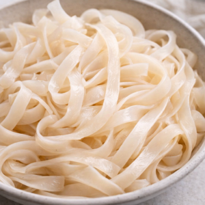 Rice noodles as the foundation
Wide or medium rice noodles are ideal here. They soften easily and don’t need boiling if soaked properly. They also hold warmth well, which makes the meal feel more satisfying without heaviness.
They’re neutral, familiar, and reliable — qualities that matter more than novelty on tired days.