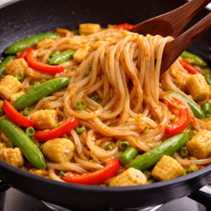 Add the noodles and sauce together. This is where the dish becomes itself. Toss slowly. Let the heat work gradually. Resist the urge to rush or over-stir.